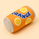 Gioco in peluche a forma di lattina all’arancia per cani, su sfondo beige chiaro coordinato al sito